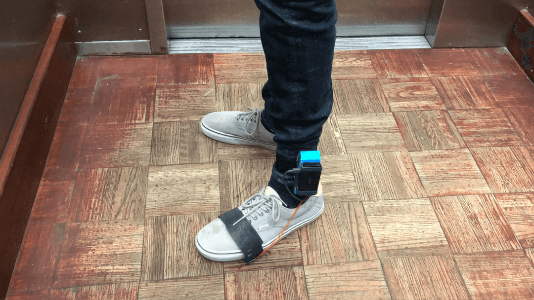 A raspberry pi and camera strapped around a person's ankle