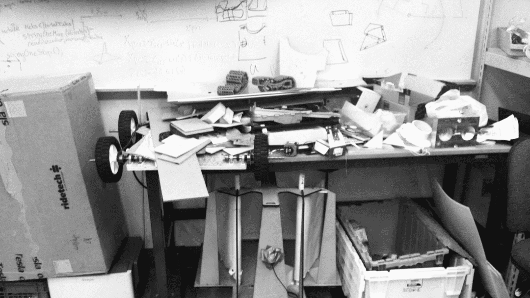 Junk materials scattered ontop of a desk and sitting on the floor