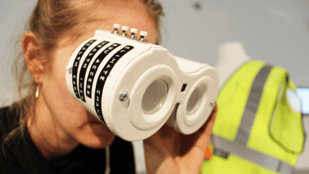 Someone looking through a binoculars device