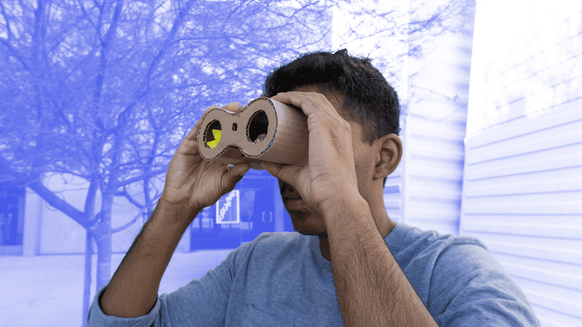 Closeup of someone looking through a cardboard binocular