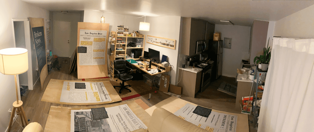 Panorama of a room with large sheets of plywood scattered on the floor